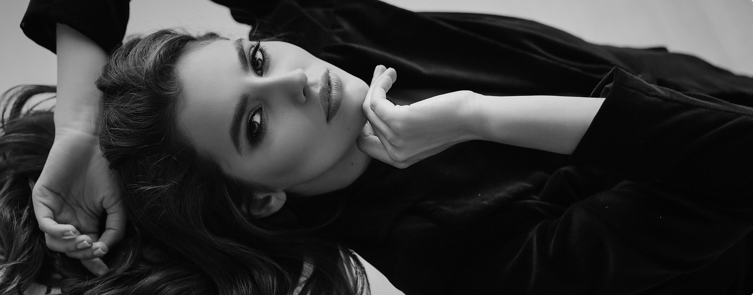 Woman in black outfit, posing elegantly.