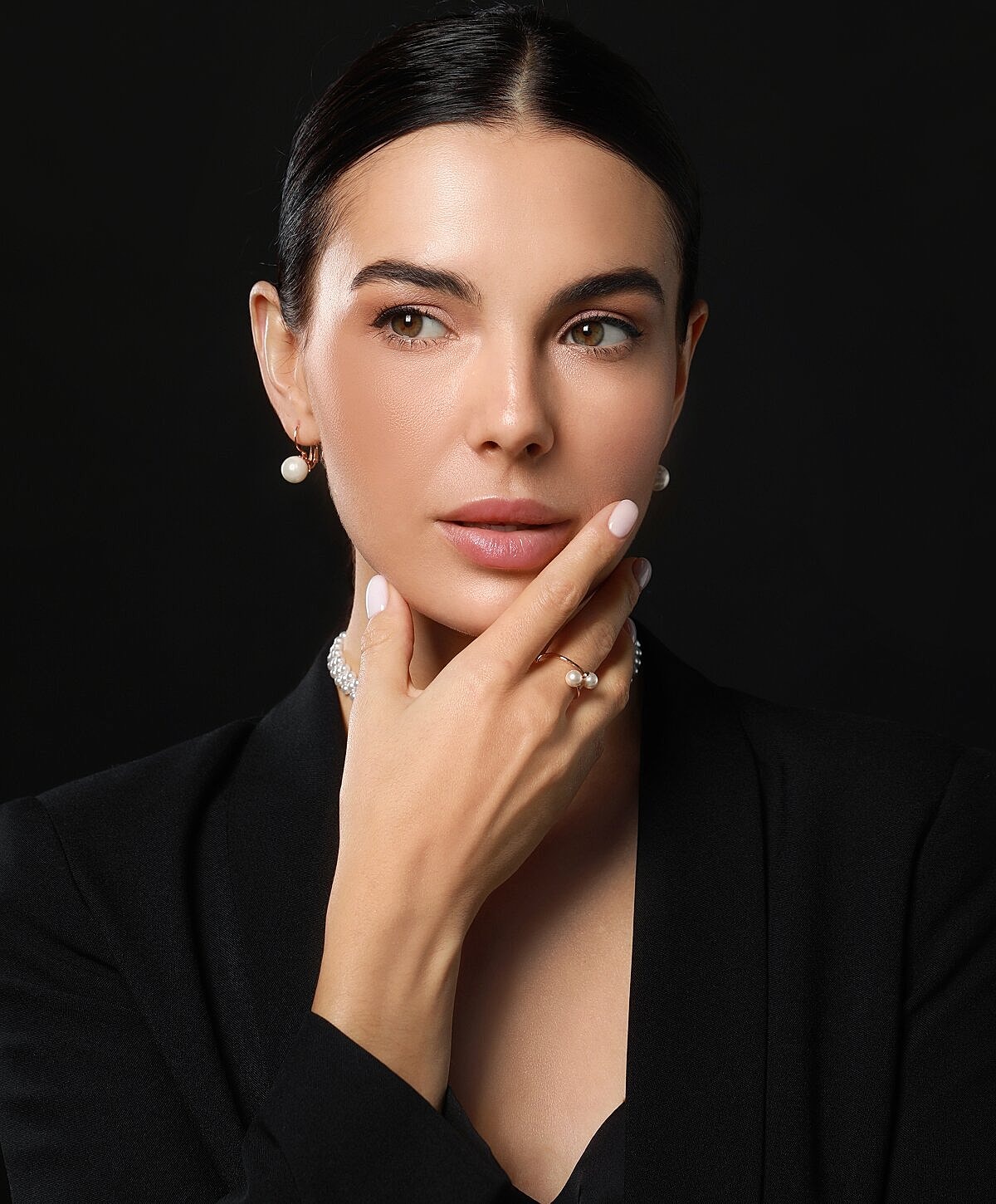 Woman with elegant jewelry and sophisticated pose.