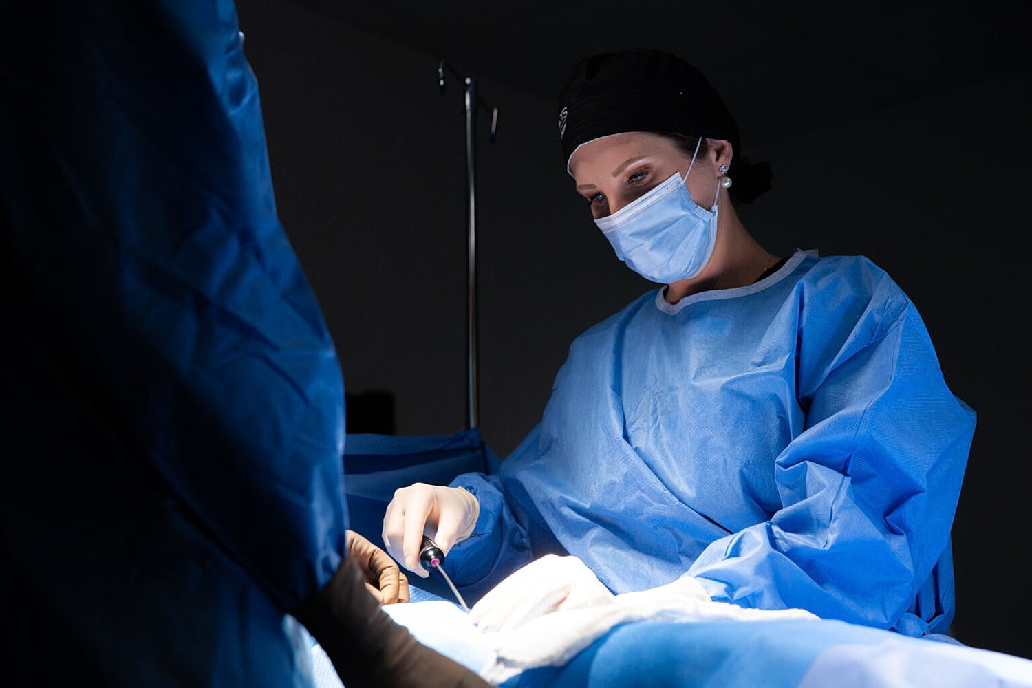 Surgeon performing a procedure in operating room.