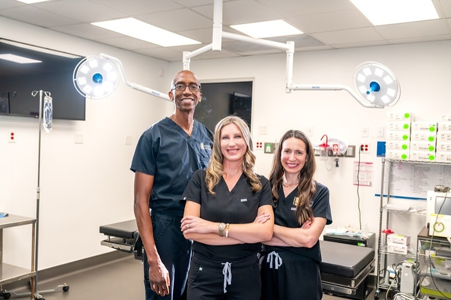 Medical professionals posing in a surgical room.