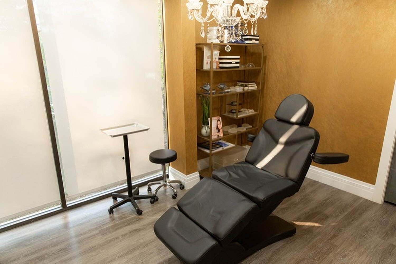 Modern aesthetic treatment room with black chair.