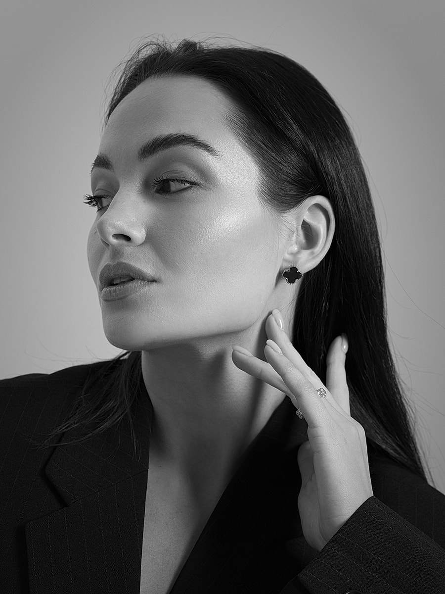 Black and white portrait of a woman wearing earrings.