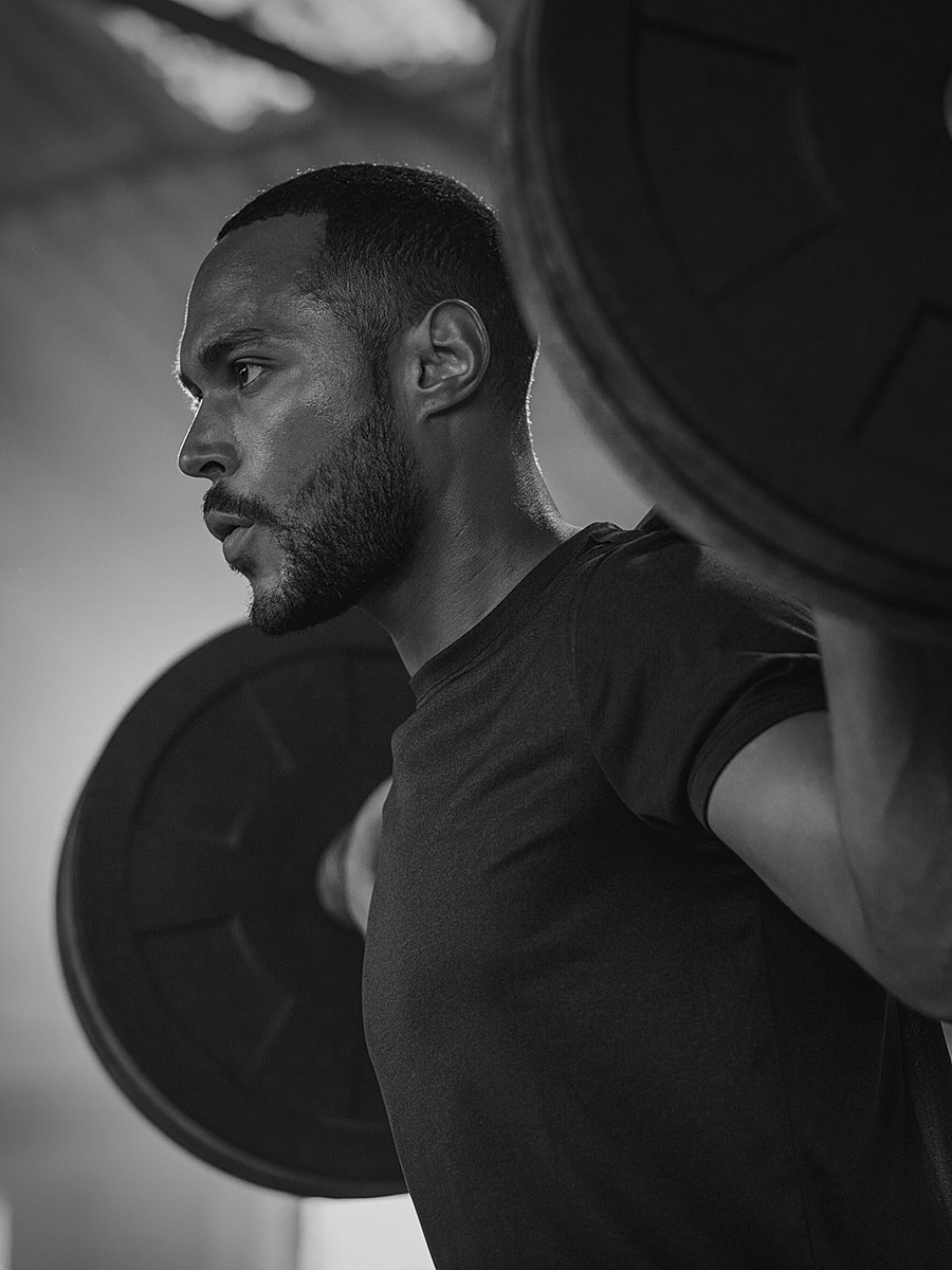 Man lifting weights in black and white.