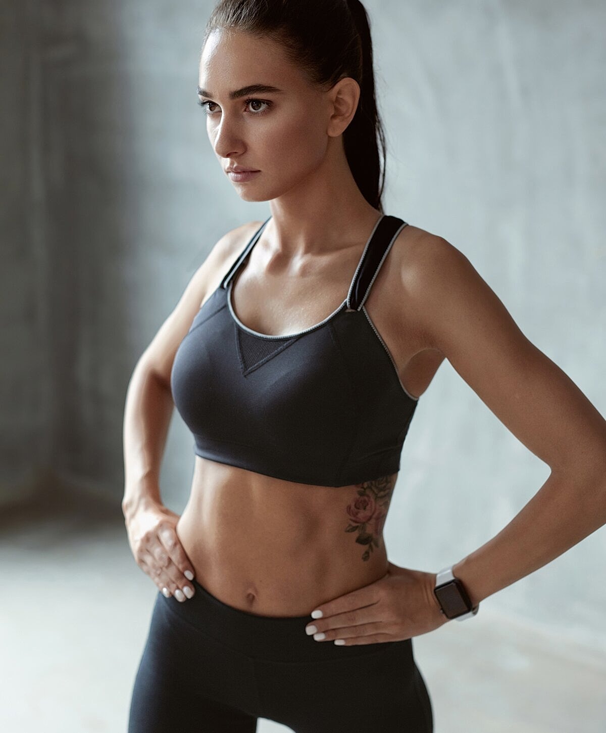 Fit woman in sportswear posing confidently indoors.