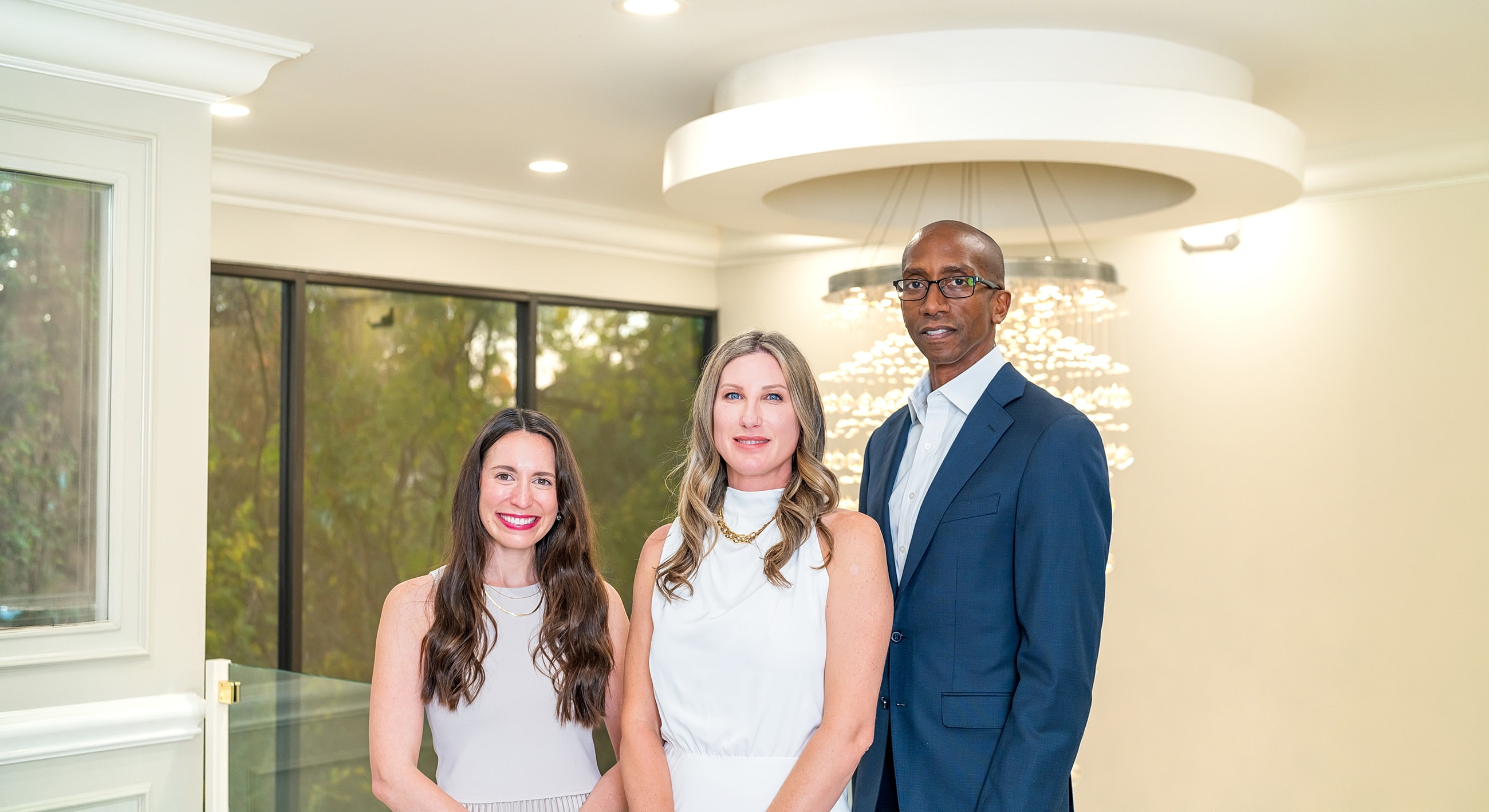 Three professionals posing in a modern interior.