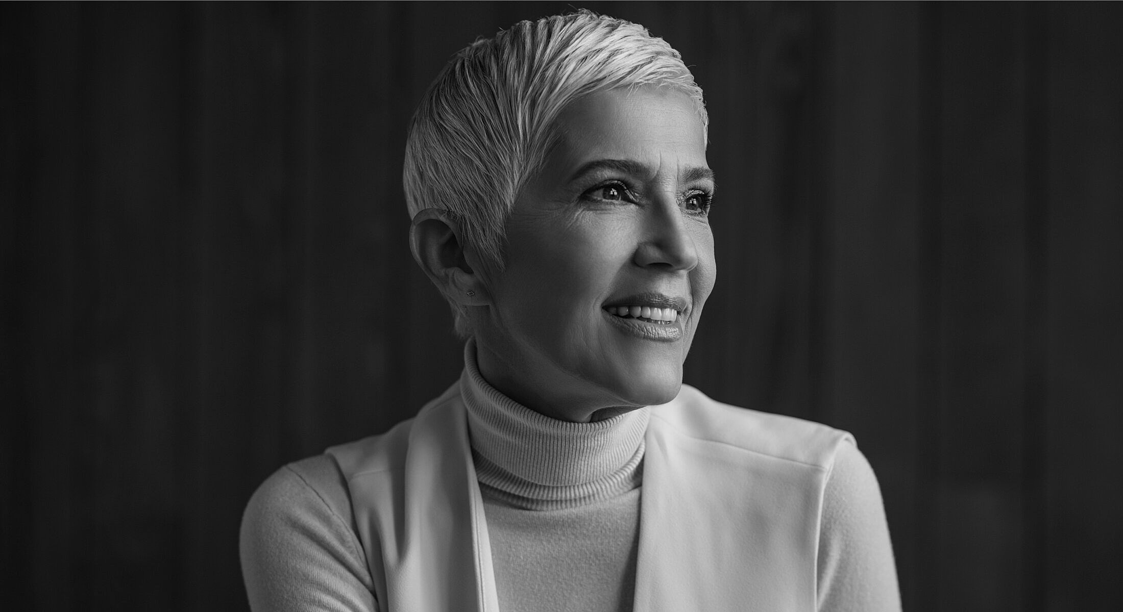 Smiling woman with short, light-colored hair.