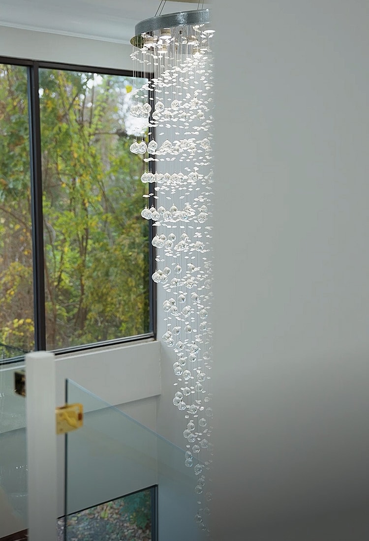 Chandelier with cascading crystal design and natural light.