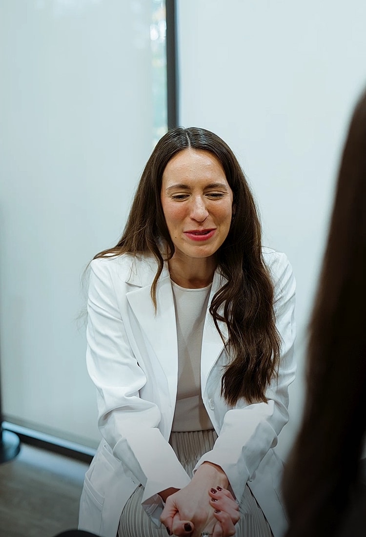 Female professional in white coat smiling warmly.