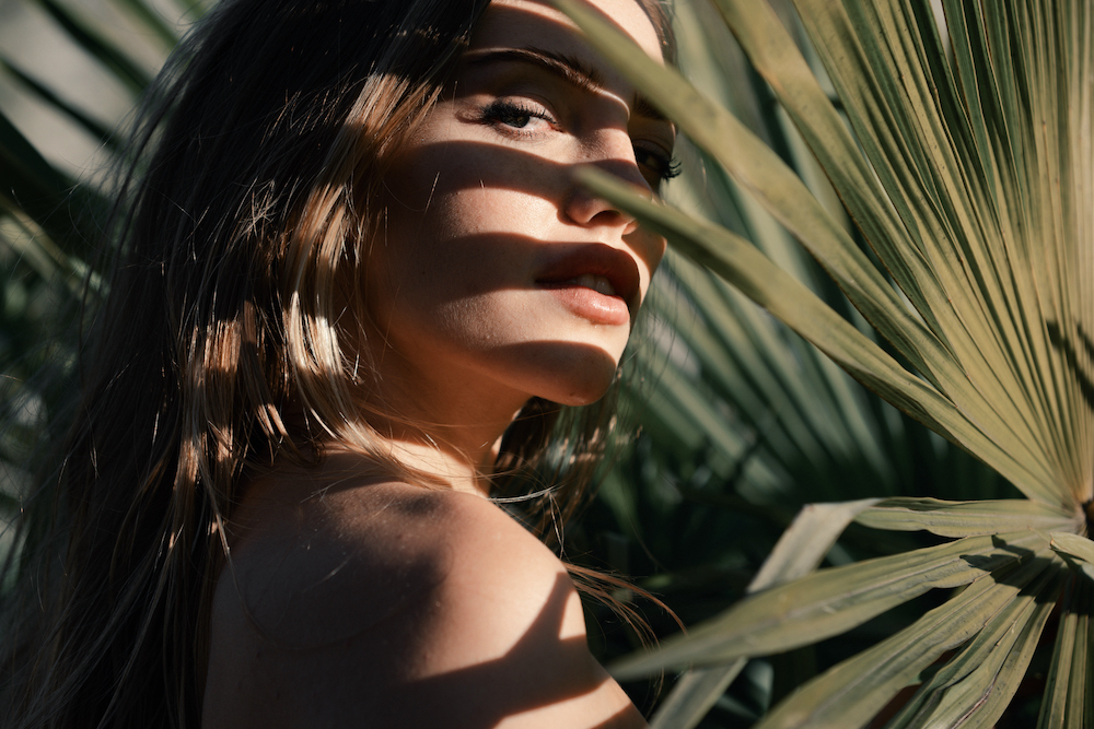 houston plastic surgery model with palm leaves shadowing her face
